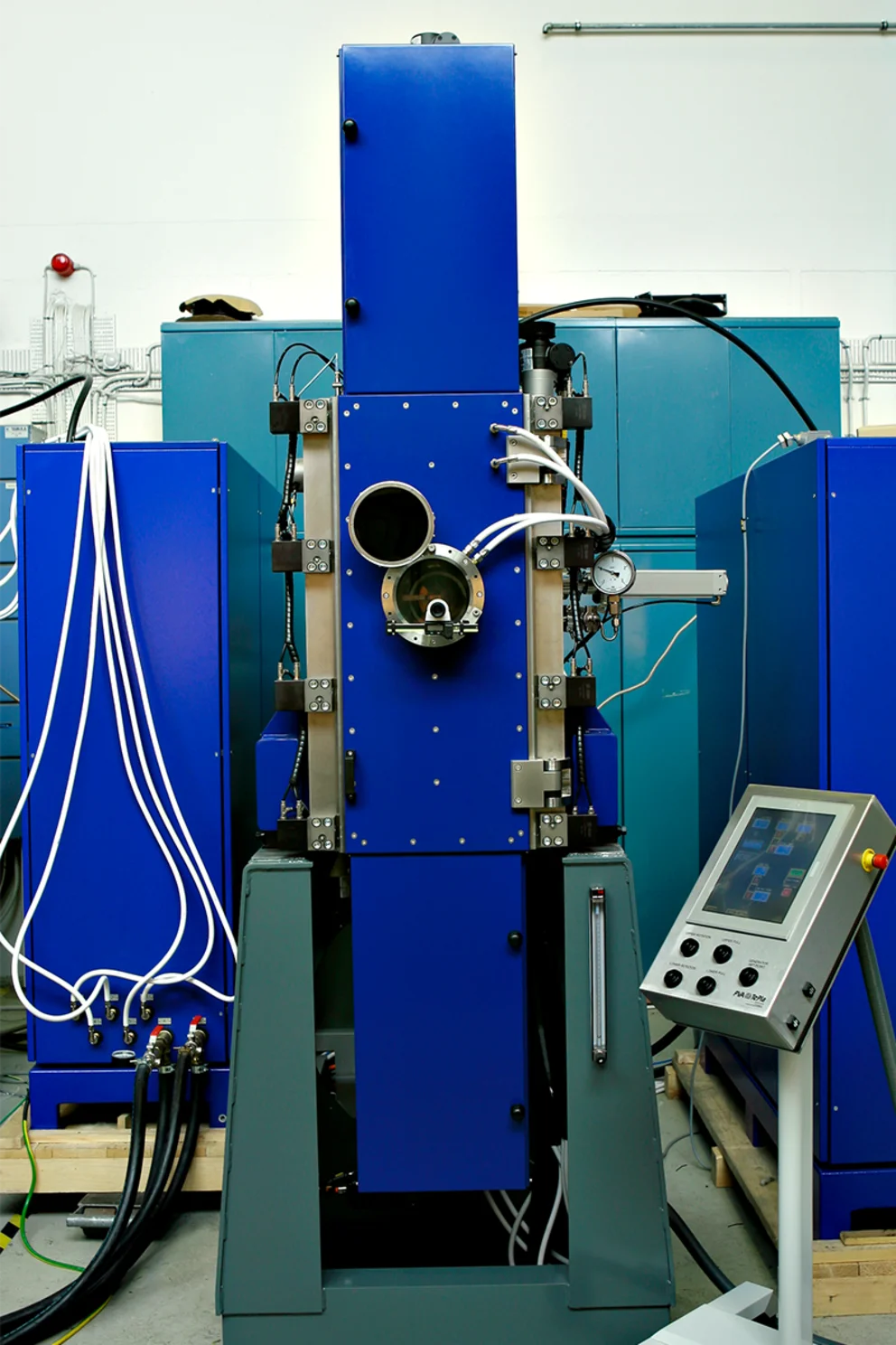 Float‑zone crystal growth system with central vertical chamber and control unit.