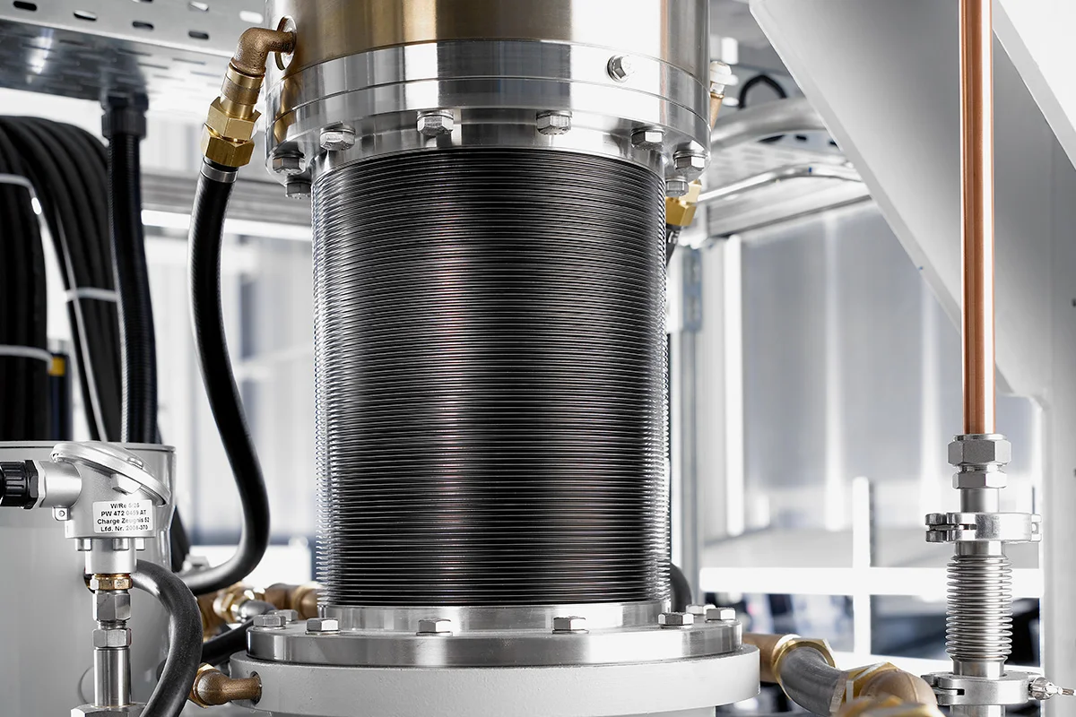 Close-up of a lifting cylinder on an industrial hot-press system.