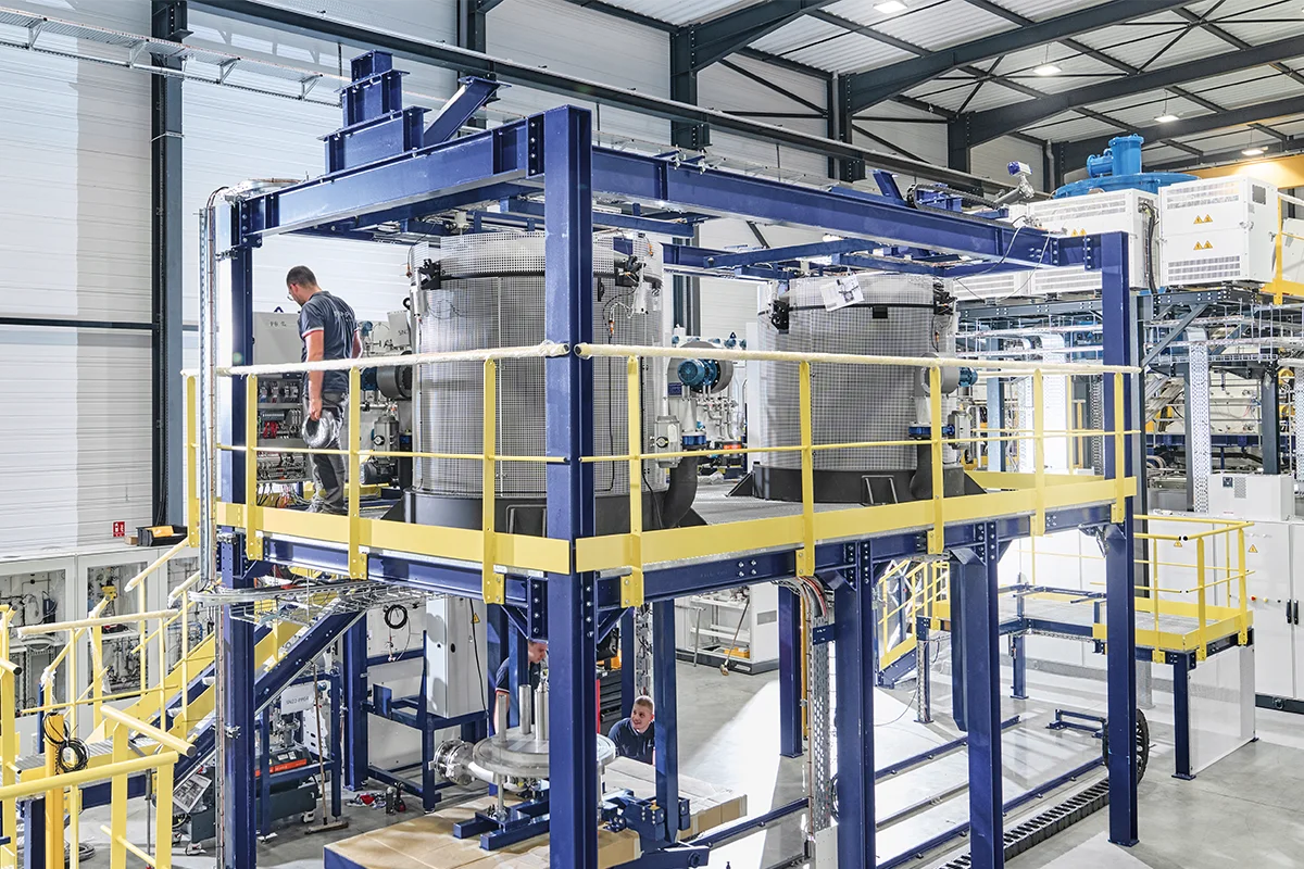 Fluoride Ion Cleaning System with blue steel frame structure in an industrial manufacturing plant.