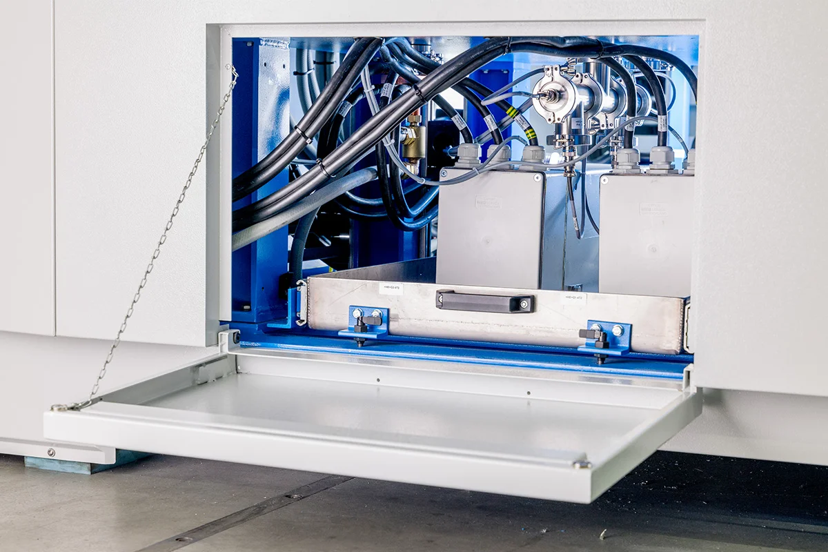 Open access panel of the Alu.Bond revealing internal cables, hoses, and technical components.