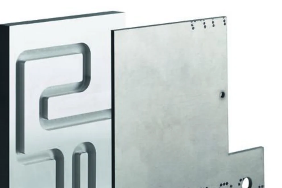 Close-up of a soldered metallic part showing cutting inserts with circular and triangular shapes.