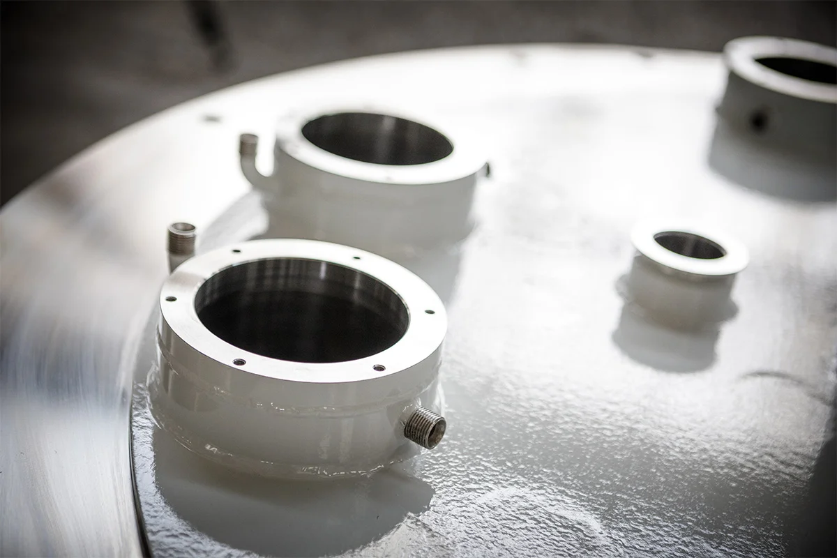 Close-up of crystal growth vessel openings with metal flanges and condensation on the surface