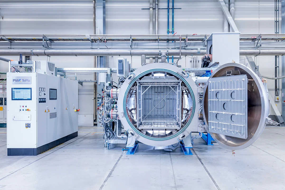 Vacuum sintering furnace in production hall with front door open.