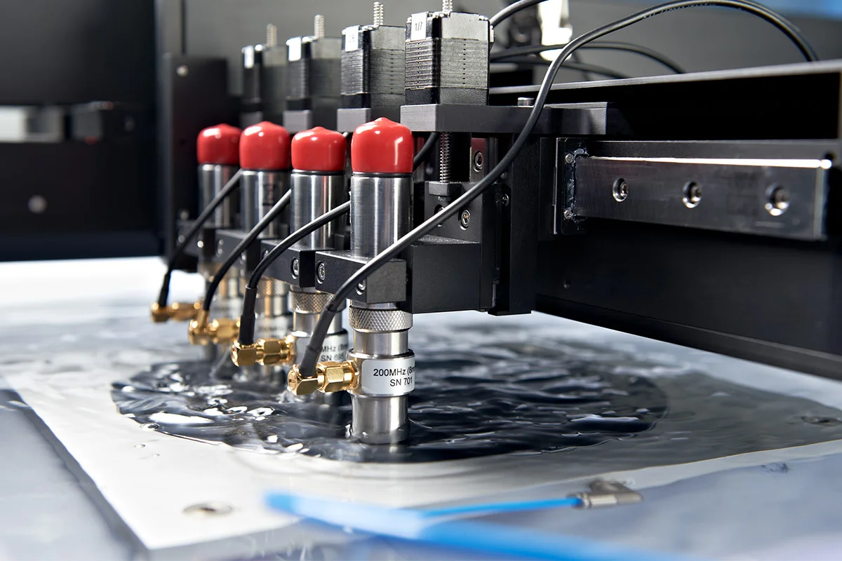 SAM system with multiple transducers inspecting a semiconductor wafer.