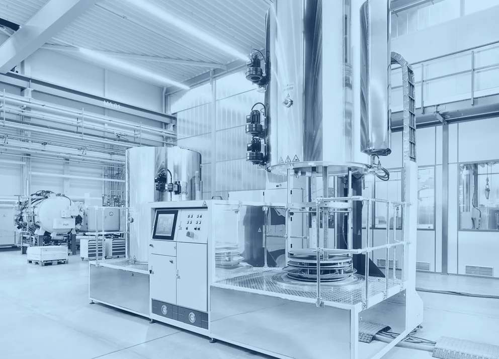 Pulse plasma nitriding system with vacuum chamber, electrodes, and connected process components inside an industrial facility