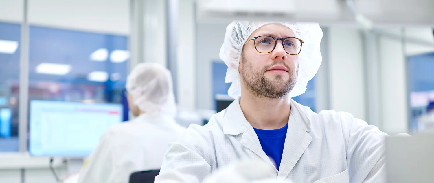 Person operating equipment in a cleanroom.