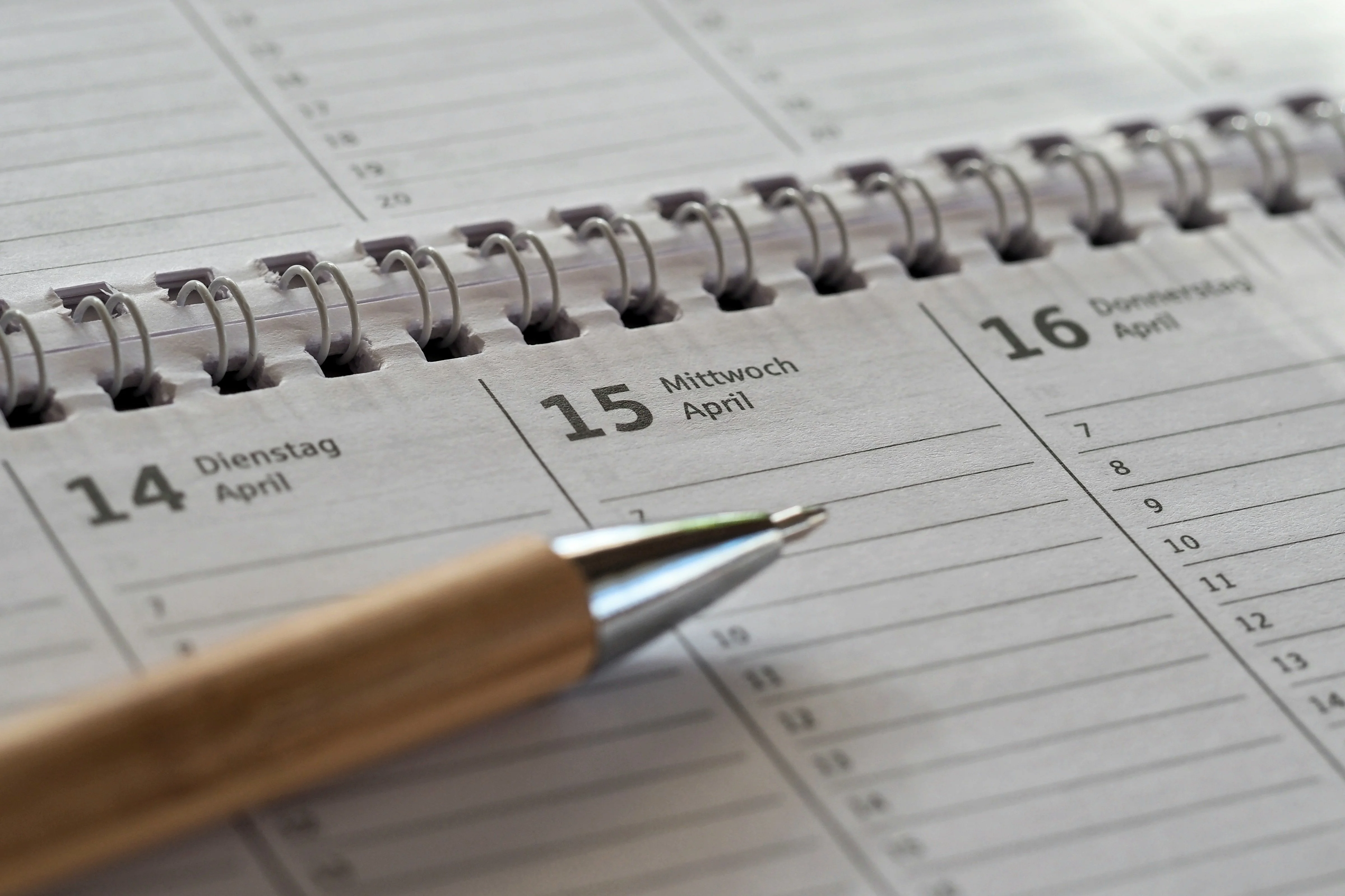 Close‑up of a planner with a pen resting on the calendar pages