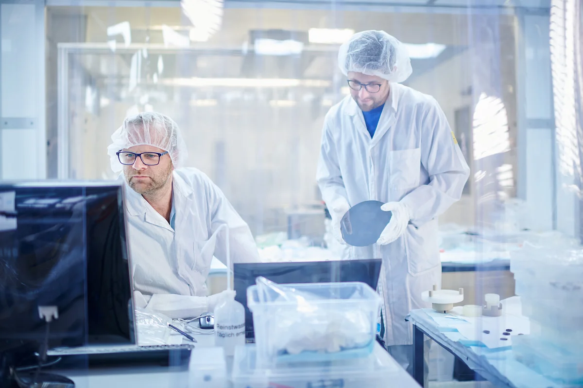 Two people working together in a cleanroom environment