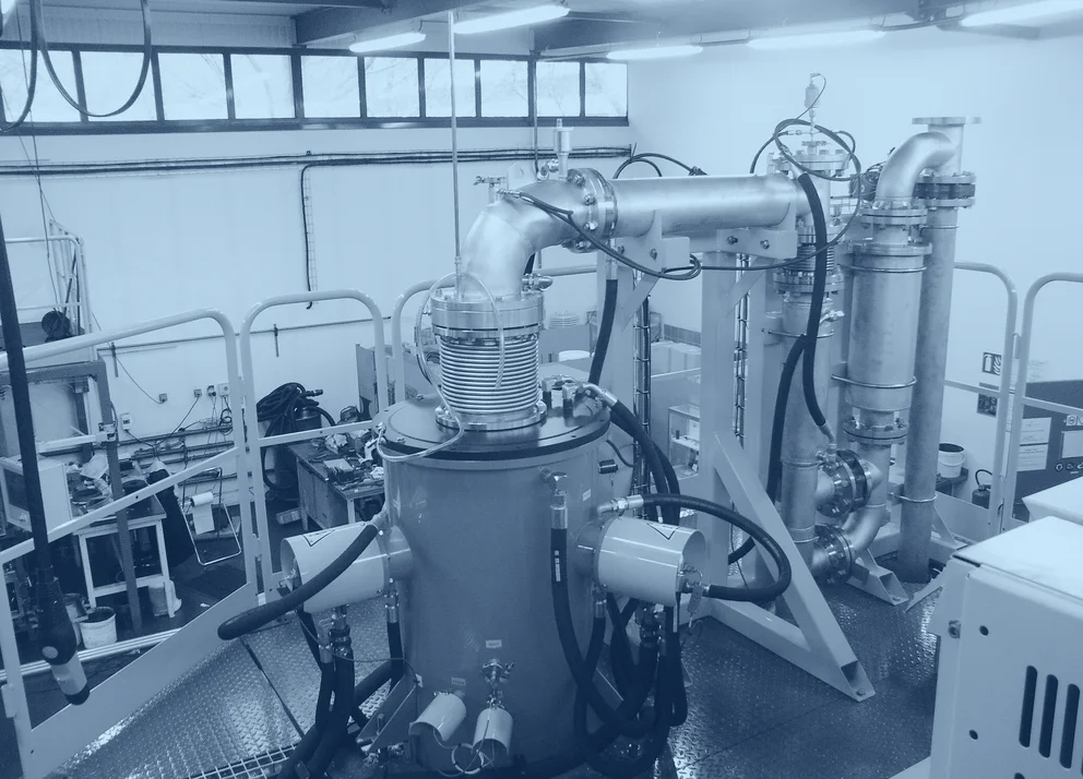 Industrial fluidized bed reactor system with connected piping, gas lines, and process components inside a production facility