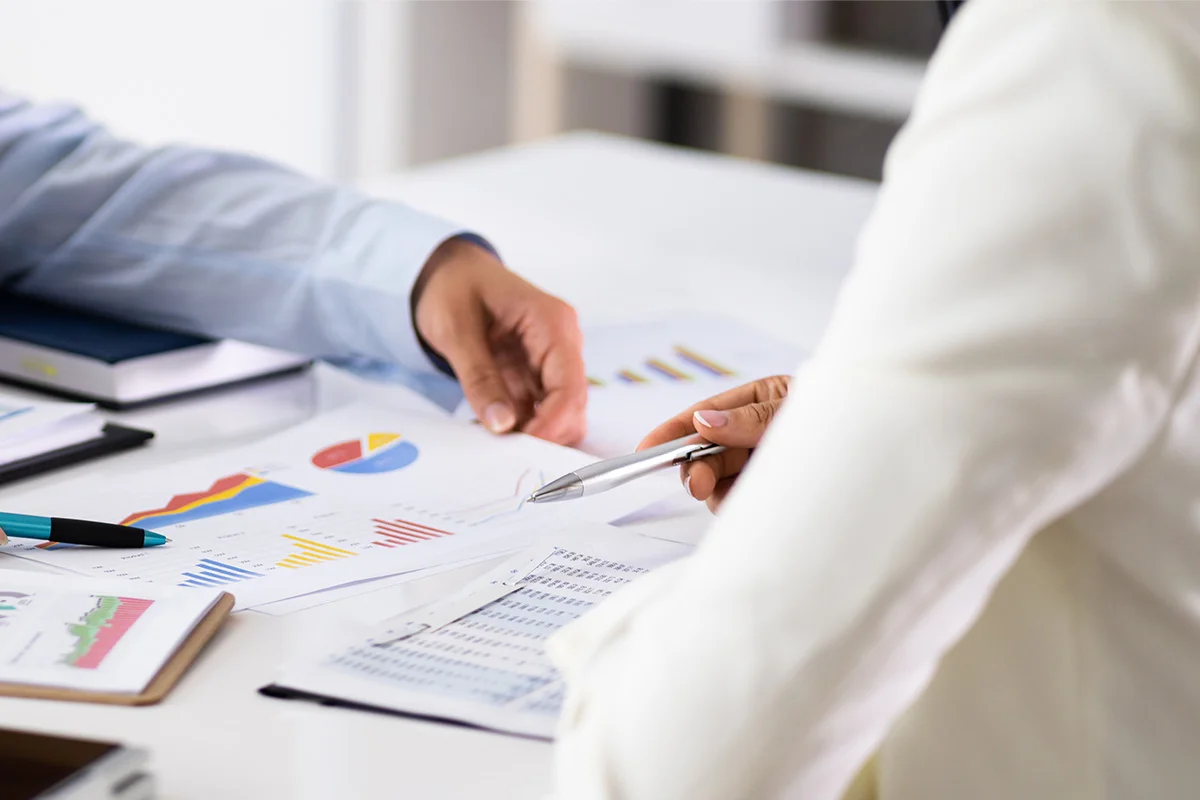 Business meeting reviewing financial charts and documents
