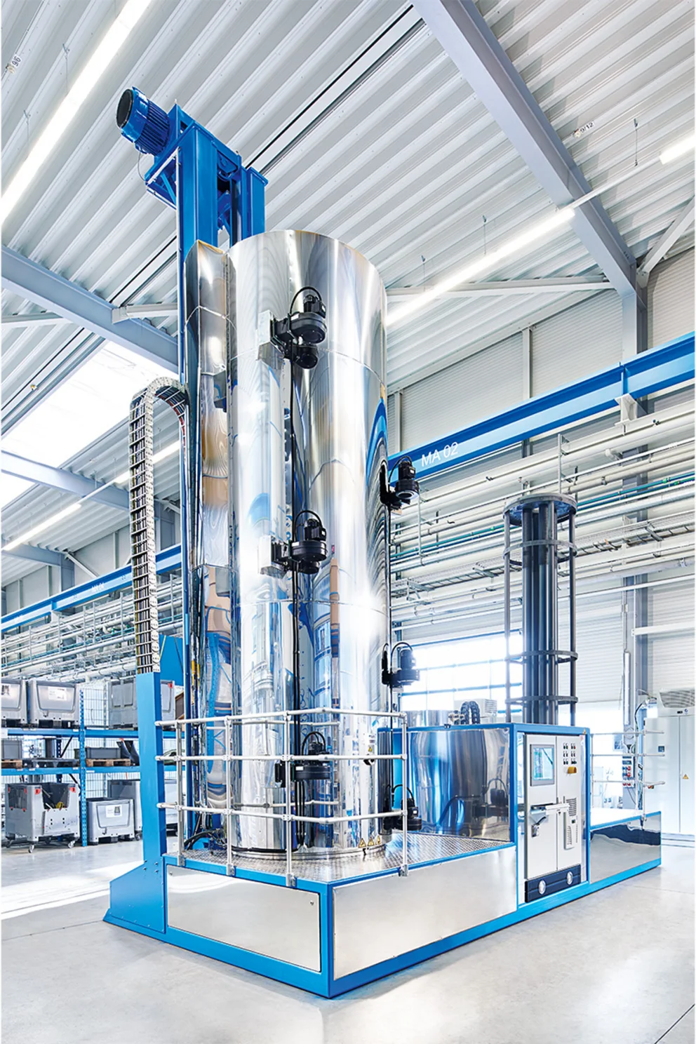 Tall PulsPlasma® nitriding system with vertical tanks and piping in a bright production hall.